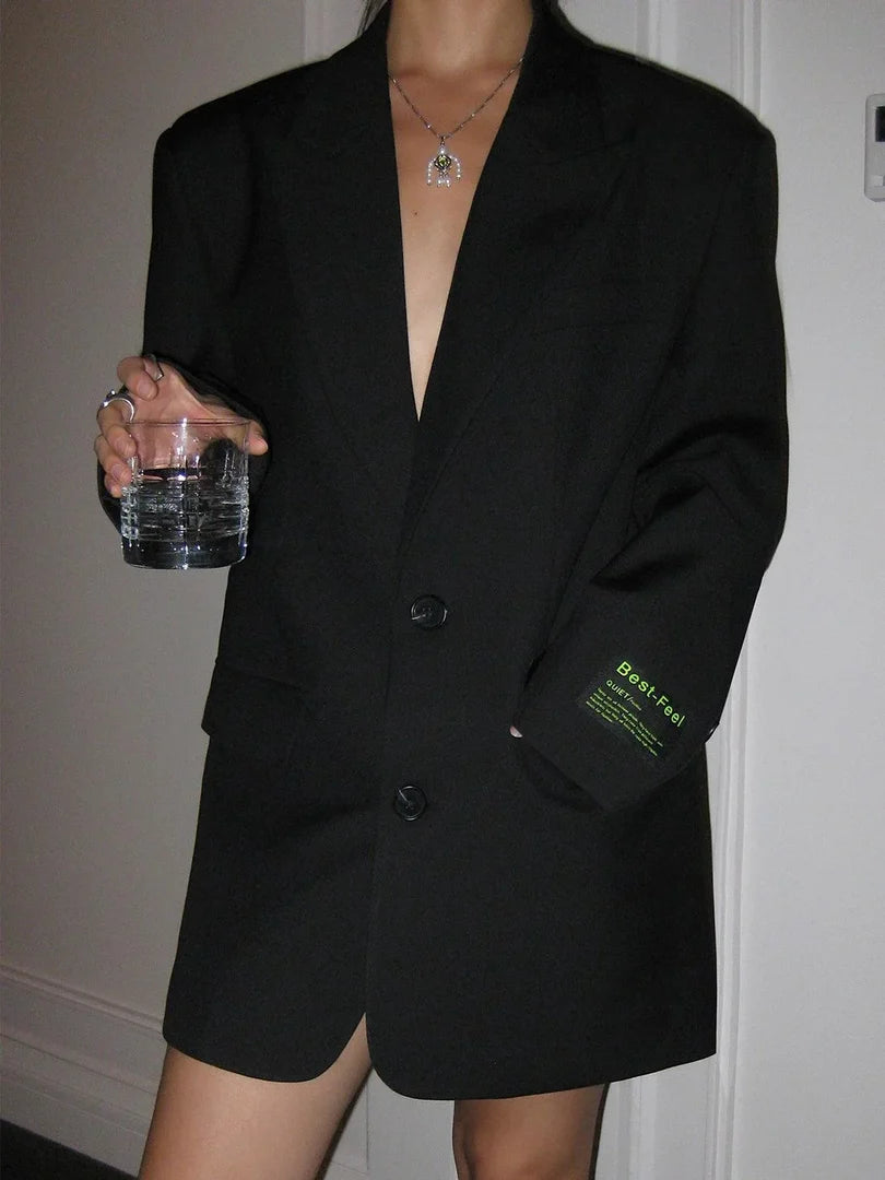 Blazer oversize para mujer en negro con solapas anchas y dos botones, vista frontal